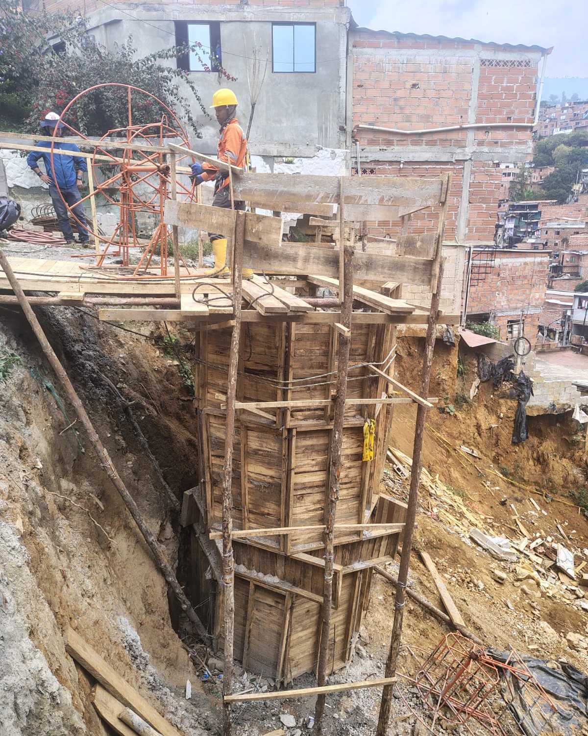 Supervisor de Construcciones M&Q con arnés dirigiendo la formaleta de un caisson en ladera